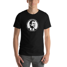 Load image into Gallery viewer, Man wearing a black unisex t-shirt, featuring the Cuomo Sapiens S.U.D.L.T. SEAL graphic in white.