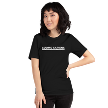 Load image into Gallery viewer, Woman wearing a black unisex t-shirt, featuring the Cuomo Sapiens S.U.D.L.T. graphic in white.