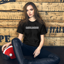 Load image into Gallery viewer, Woman with a scooter helmet next to some crates, wearing a black unisex t-shirt, featuring the Cuomo Sapiens S.U.D.L.T. graphic in white.