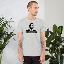 Load image into Gallery viewer, Man standing next to some plants, wearing a heather grey unisex t-shirt, featuring the Cuomo Sapiens NO BALONEY graphic in black.