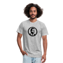 Load image into Gallery viewer, Man wearing a heather grey unisex t-shirt, featuring the Cuomo Sapiens S.U.D.L.T. SEAL graphic in black.