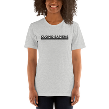 Load image into Gallery viewer, Woman wearing a heather grey unisex t-shirt, featuring the Cuomo Sapiens S.U.D.L.T. graphic in black.
