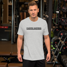 Load image into Gallery viewer, Man at the gym, wearing a heather grey unisex t-shirt, featuring the Cuomo Sapiens S.U.D.L.T. graphic in black.