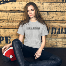 Load image into Gallery viewer, Woman with a scooter helmet next to some crates, wearing a heather grey unisex t-shirt, featuring the Cuomo Sapiens S.U.D.L.T. graphic in black.
