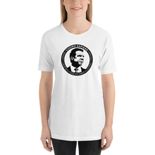 Load image into Gallery viewer, Woman wearing a white unisex t-shirt, featuring the Cuomo Sapiens S.U.D.L.T. SEAL graphic in black.