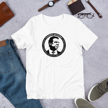 Load image into Gallery viewer, A white unisex t-shirt on the floor, featuring the Cuomo Sapiens S.U.D.L.T. SEAL graphic in black.