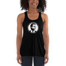 Load image into Gallery viewer, Woman wearing a black flowy racerback style tank top, featuring the Cuomo Sapiens S.U.D.L.T. SEAL graphic in white.
