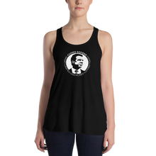 Load image into Gallery viewer, Woman wearing a black flowy racerback style tank top, featuring the Cuomo Sapiens S.U.D.L.T. SEAL graphic in white.
