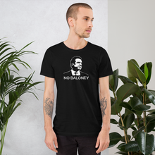 Load image into Gallery viewer, Man standing next to some plants, wearing a black unisex t-shirt, featuring the Cuomo Sapiens NO BALONEY graphic in white.
