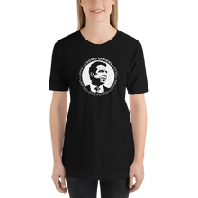 Load image into Gallery viewer, Woman wearing a black unisex t-shirt, featuring the Cuomo Sapiens S.U.D.L.T. SEAL graphic in white.
