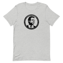 Load image into Gallery viewer, A heather grey unisex t-shirt on a flat surface, featuring the Cuomo Sapiens S.U.D.L.T. SEAL graphic in black.
