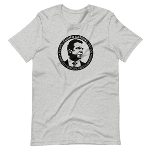 A heather grey unisex t-shirt lying wrinkled on a flat surface, featuring the Cuomo Sapiens S.U.D.L.T. SEAL graphic in black.