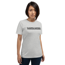 Load image into Gallery viewer, Woman wearing a heather grey unisex t-shirt, featuring the Cuomo Sapiens S.U.D.L.T. graphic in black.
