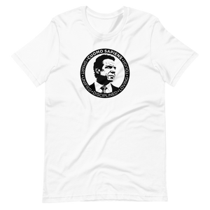 A white unisex t-shirt lying wrinkled on a flat surface, featuring the Cuomo Sapiens S.U.D.L.T. SEAL graphic in black.