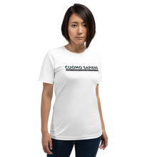 Load image into Gallery viewer, Woman wearing a white unisex t-shirt, featuring the Cuomo Sapiens S.U.D.L.T. graphic in black.
